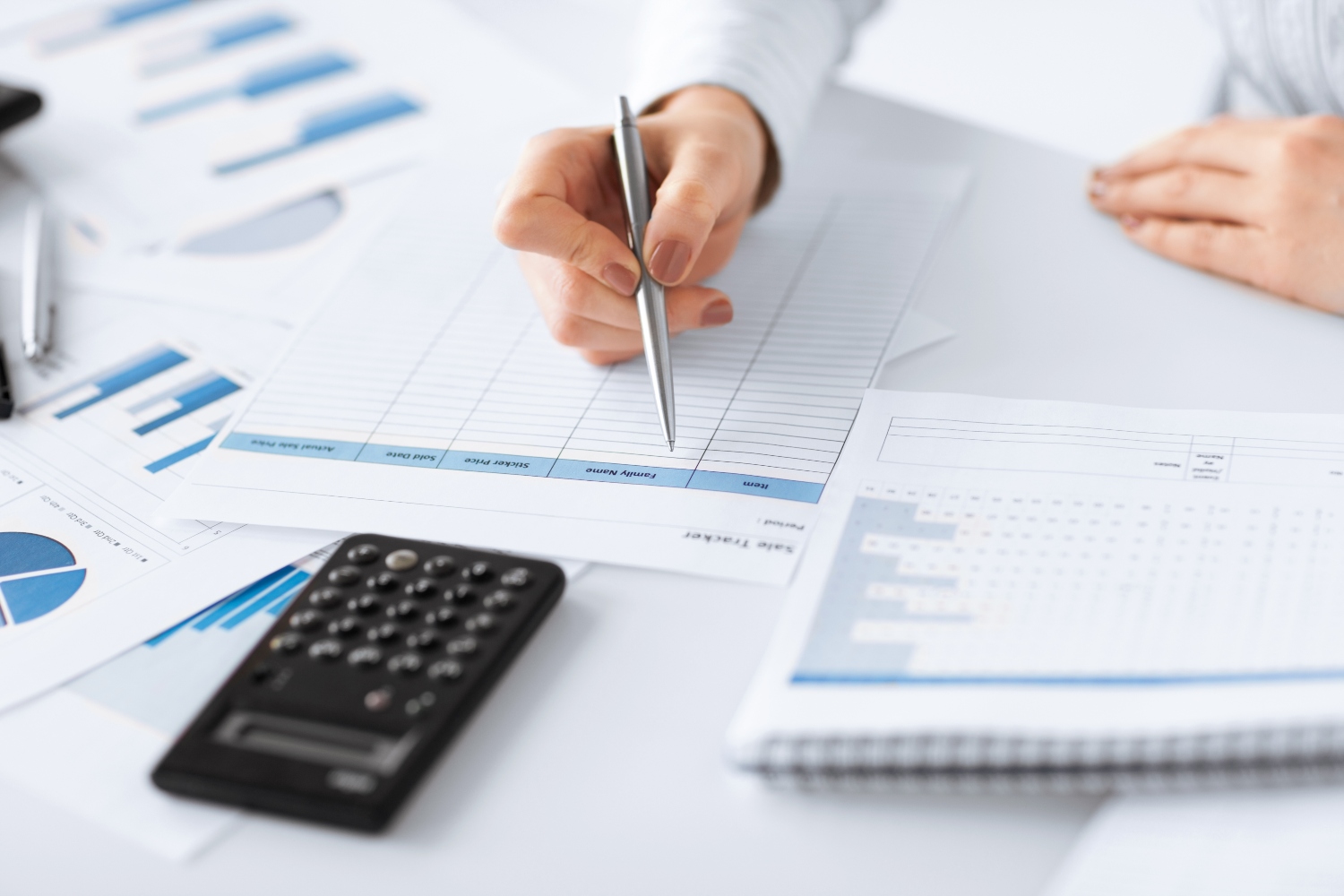 Woman hand with calculator and papers